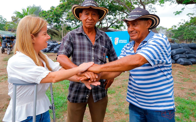 Fotografía de la gobernadora Elsa Noguera juntando manos con pequeños ganaderos beneficiados