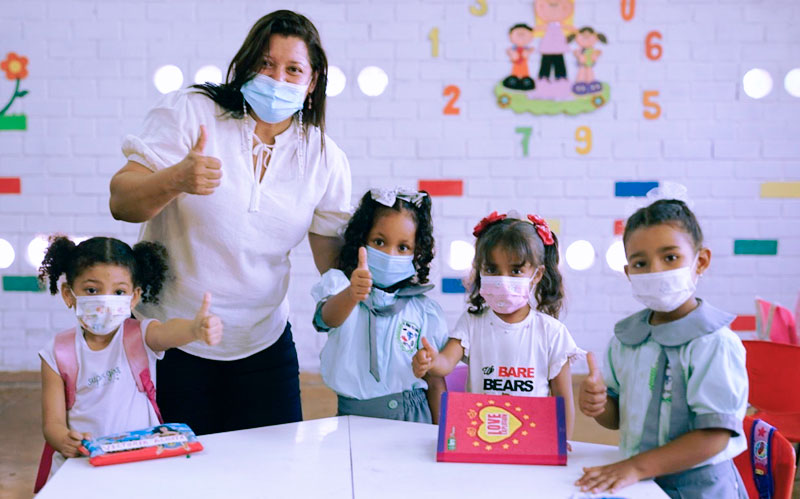 Fotografía profesora en salón de clases con niños