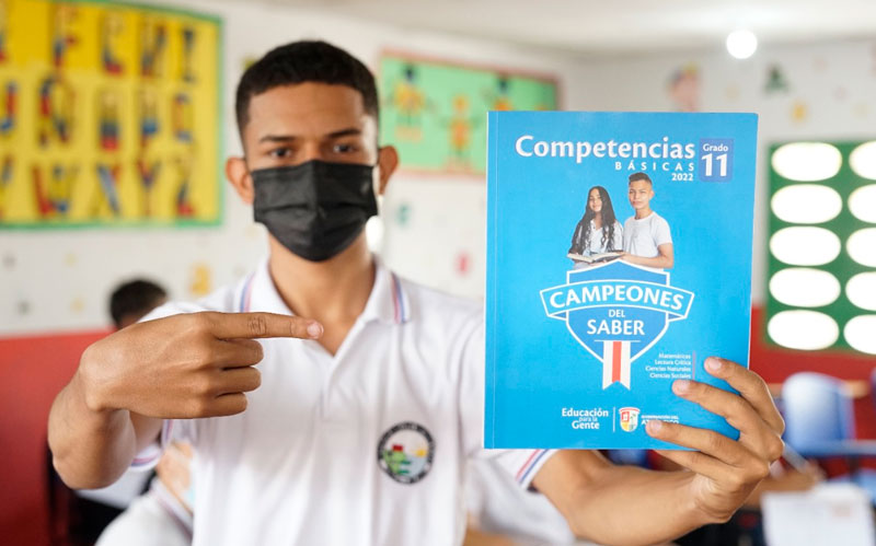 Fotografia de estudiante mostrando cartilla Campeones del Saber