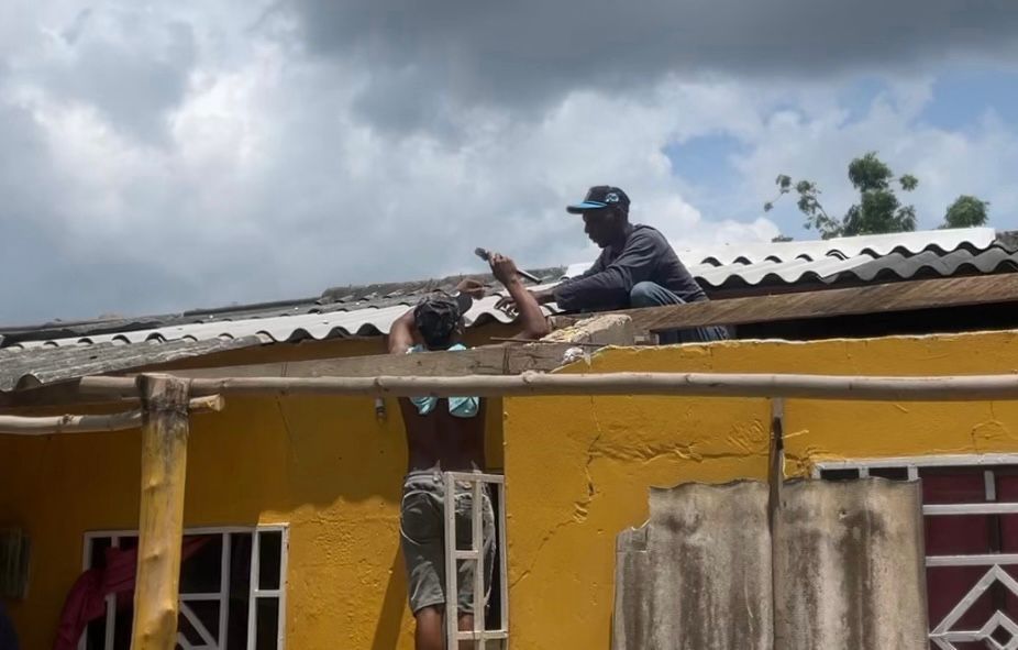 Personas arreglando una casa ante la temporada de lluvia c123