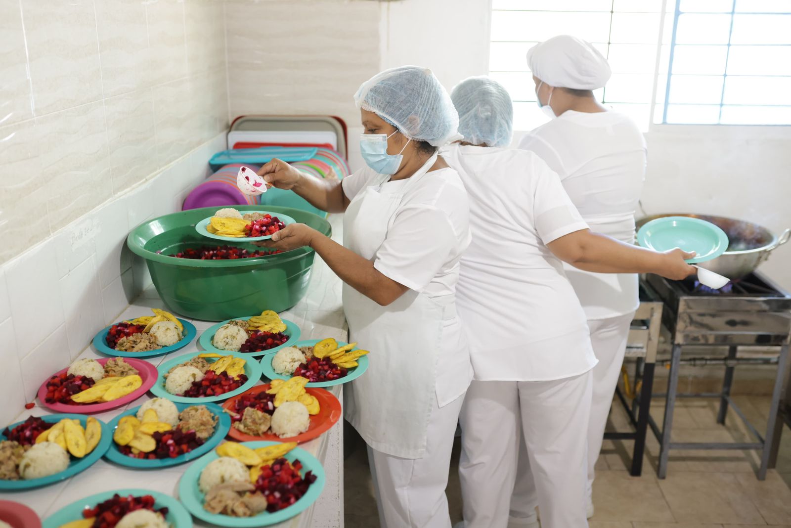 Cocinera sirviendo almuerzo en comedor estudiantil c155