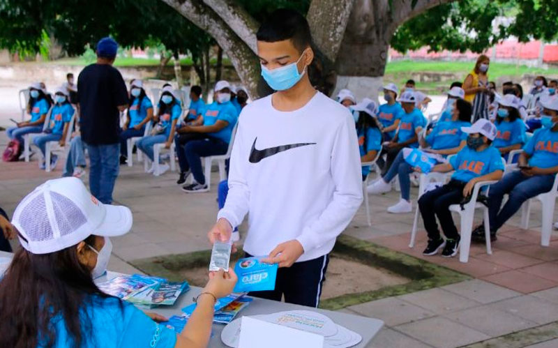 Fotografía joven recibiendo preservativo en campaña Fotografía joven recibiendo preservativo en campaña de prevención de embarazo