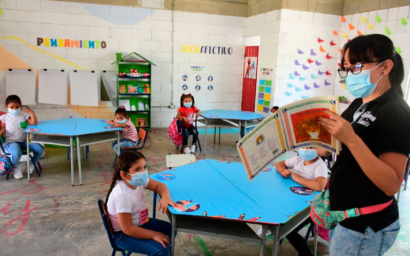 Fotografía profesora con niños en salón de clases