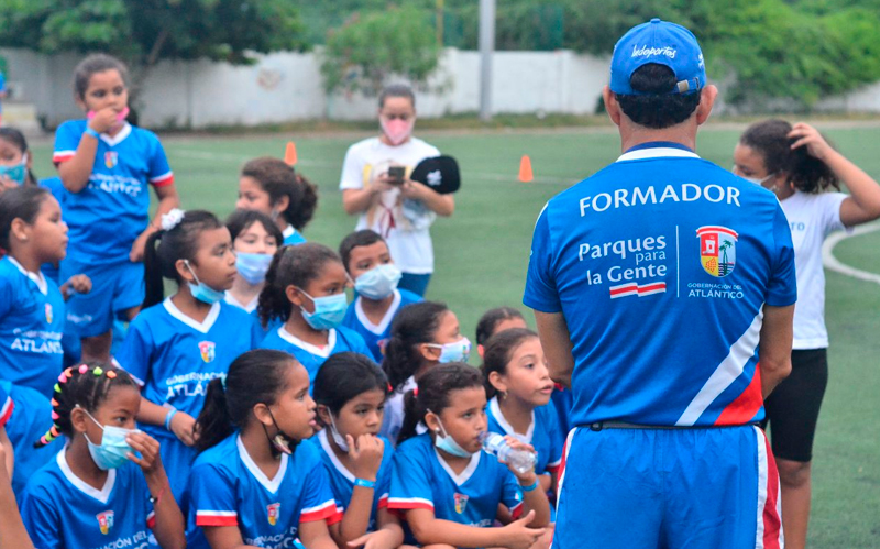 Fotografía de formador de INDEPORTES con niños en parque