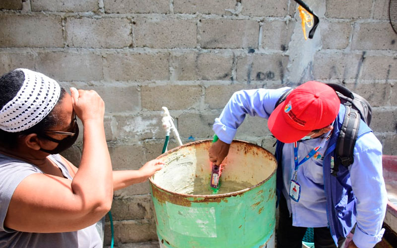 Foto funcionario de Salud revisando tanque