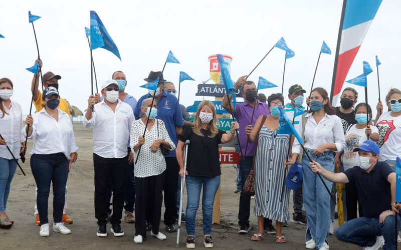 Foto gobernadora Elsa Noguera en playas sosteniendo banderín azul junto con personal asistentes al evento